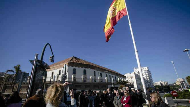 Los asistentes al acto posan para una foto bajo la bandera de la Plaza de Sevilla.