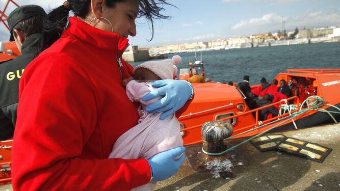 Una miembro de Cruz Roja, con un bebé rescatado.